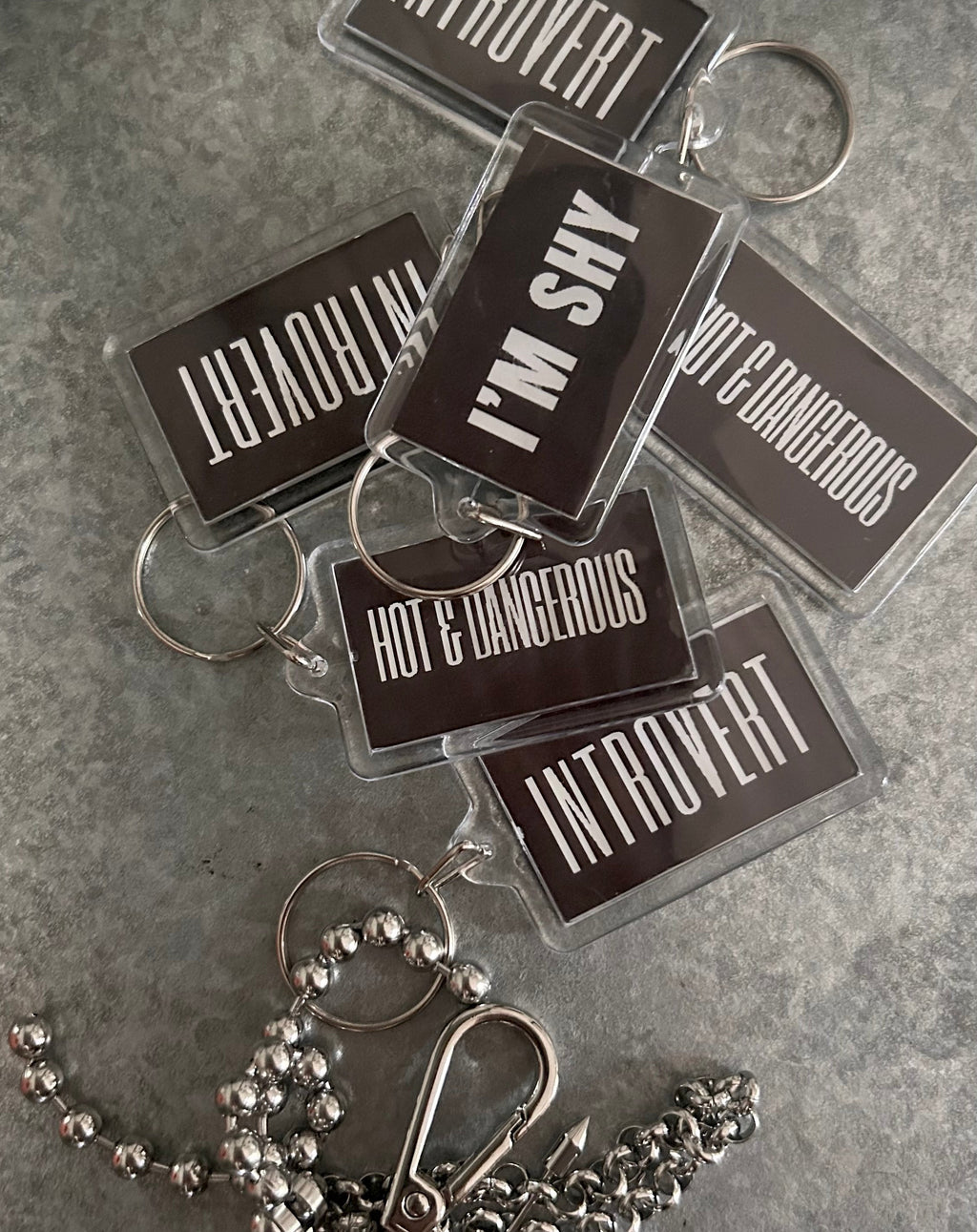 Keychains with various personality traits on a gray surface