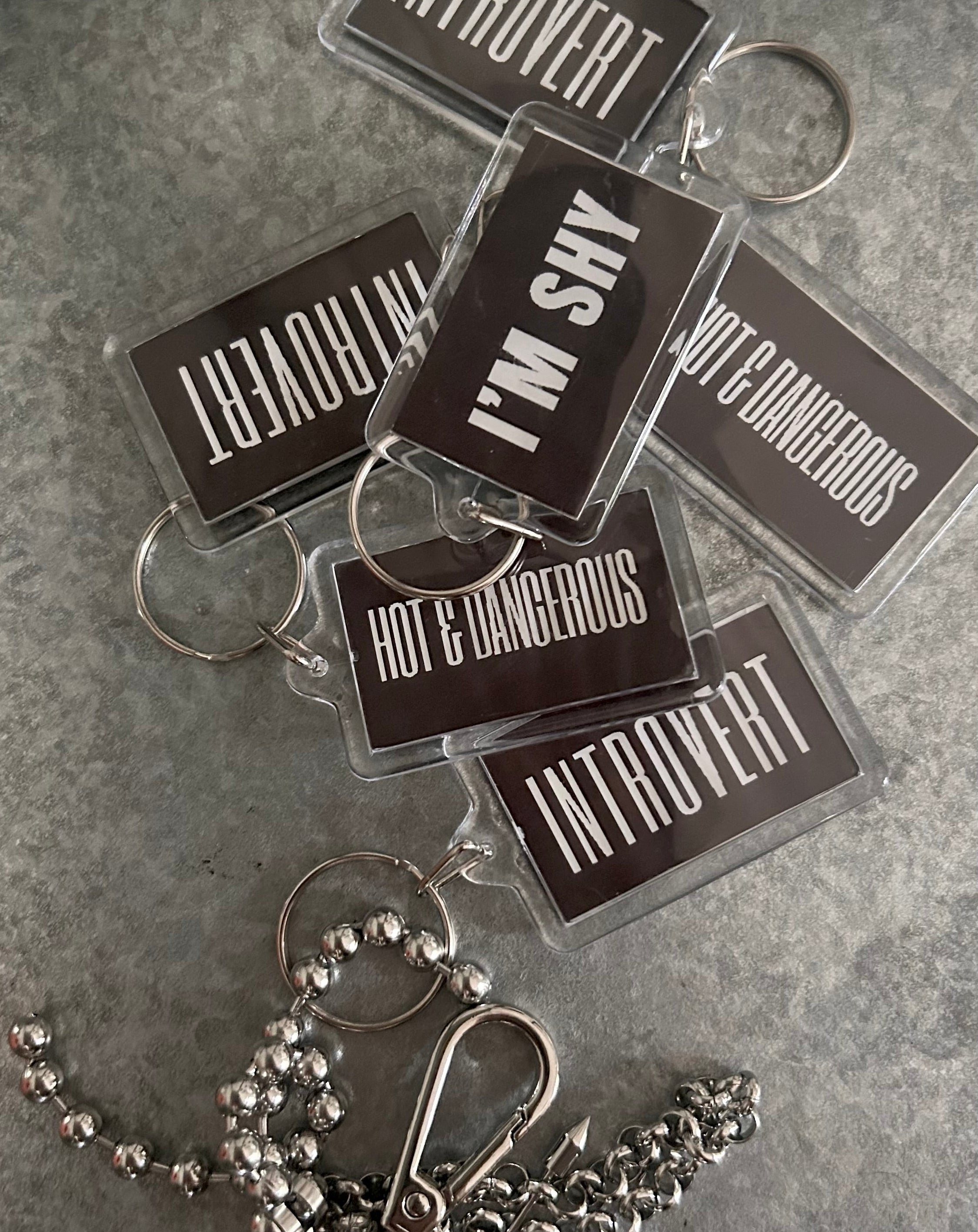 Keychains with various personality traits on a gray surface