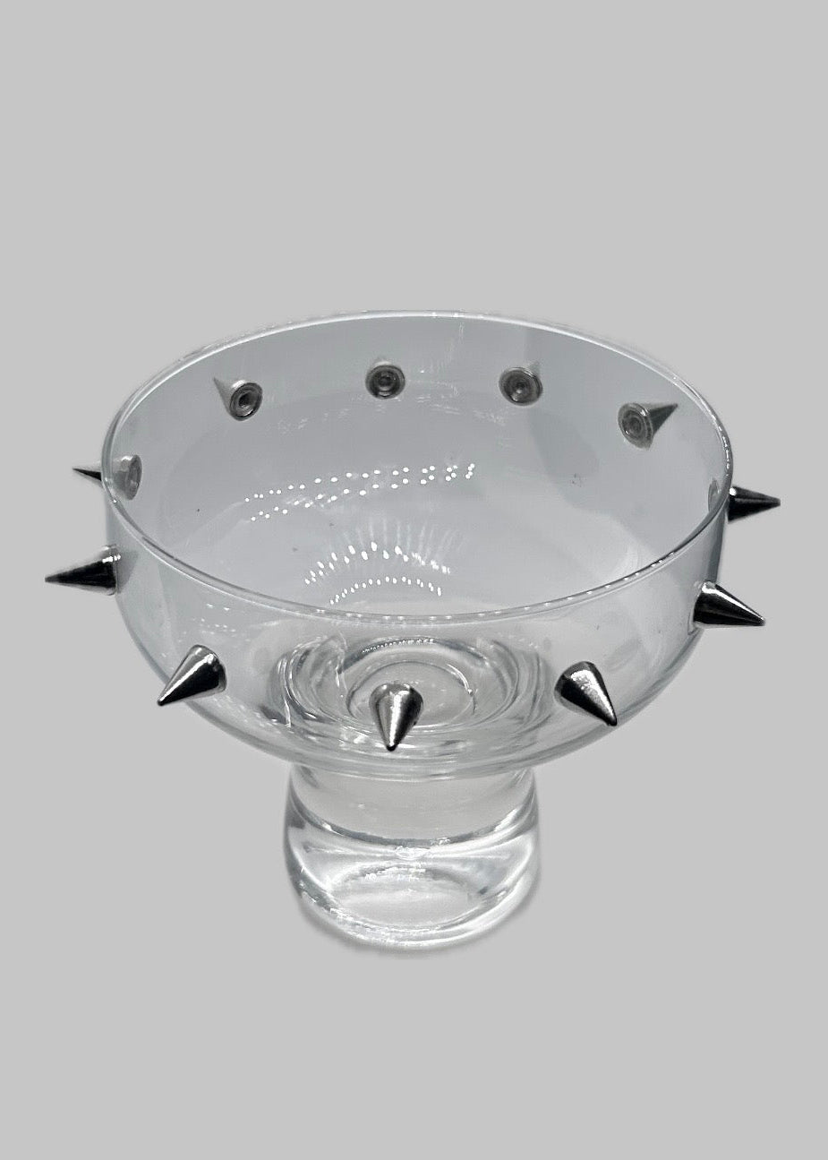 Clear glass bowl with spike-protrusions on a gray background