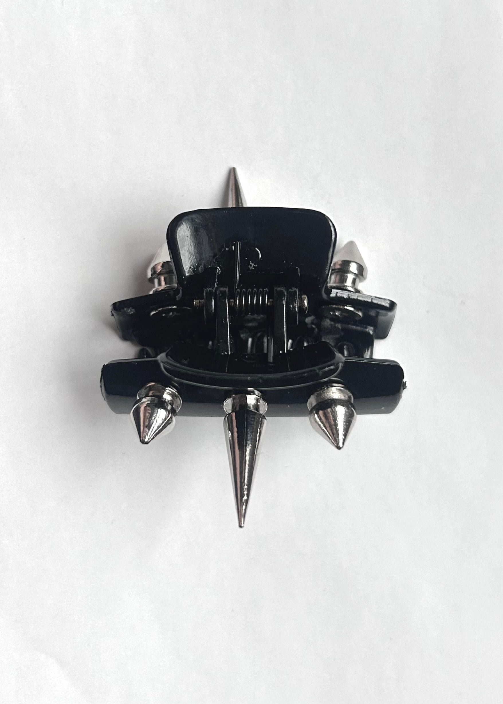 Black and silver spiked claw clip on a white background
