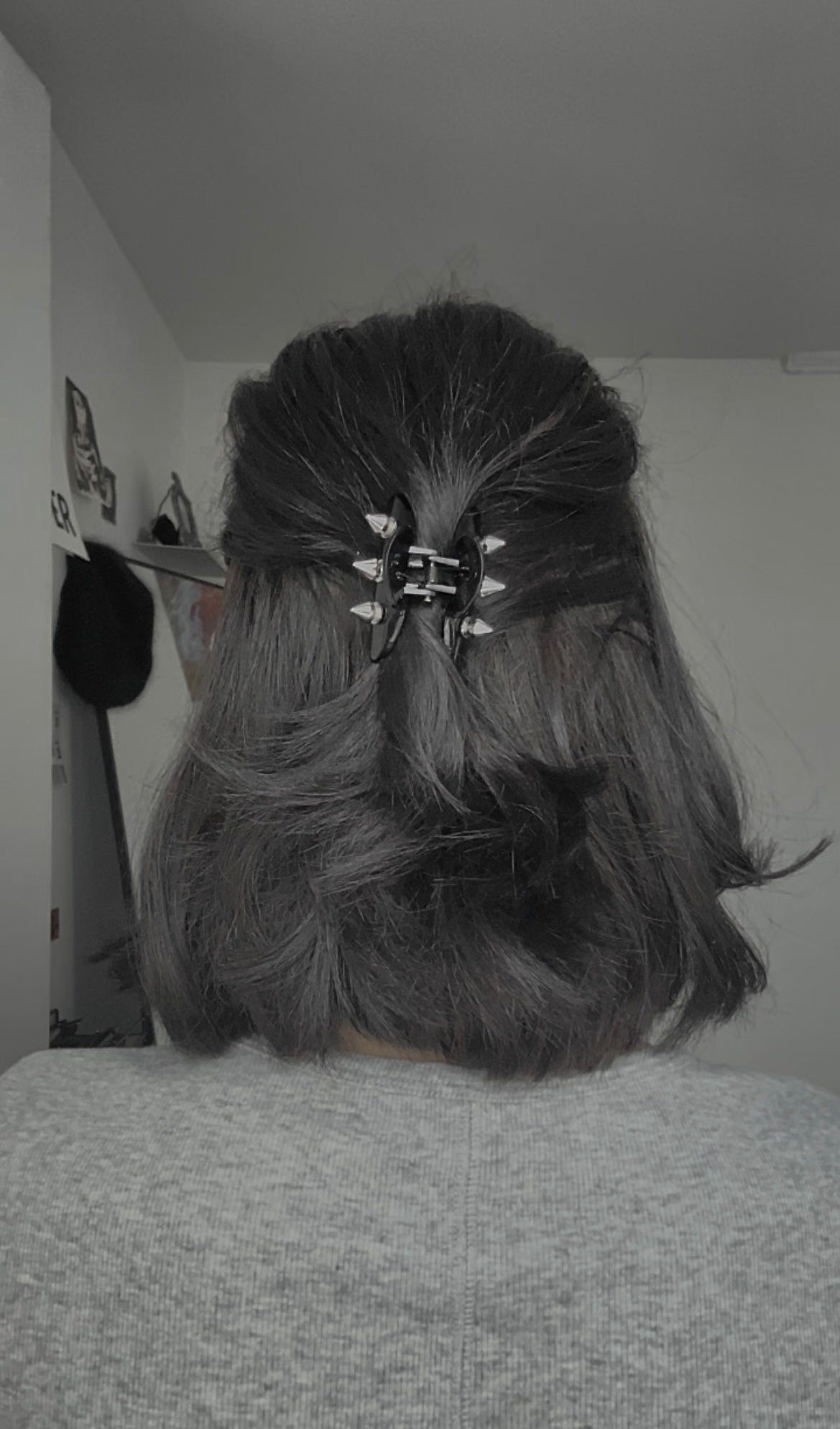 Person with styled hair featuring a decorative hair clip in an indoor setting