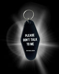 Black keychain with 'Please Don't Talk to Me' text on a dark background