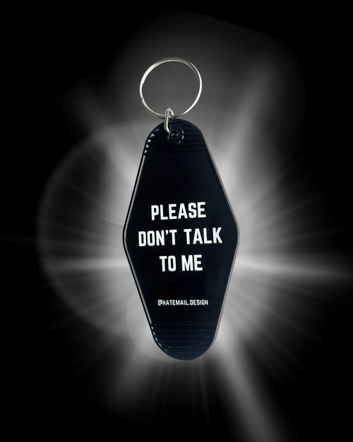 Black keychain with 'Please Don't Talk to Me' text on a dark background