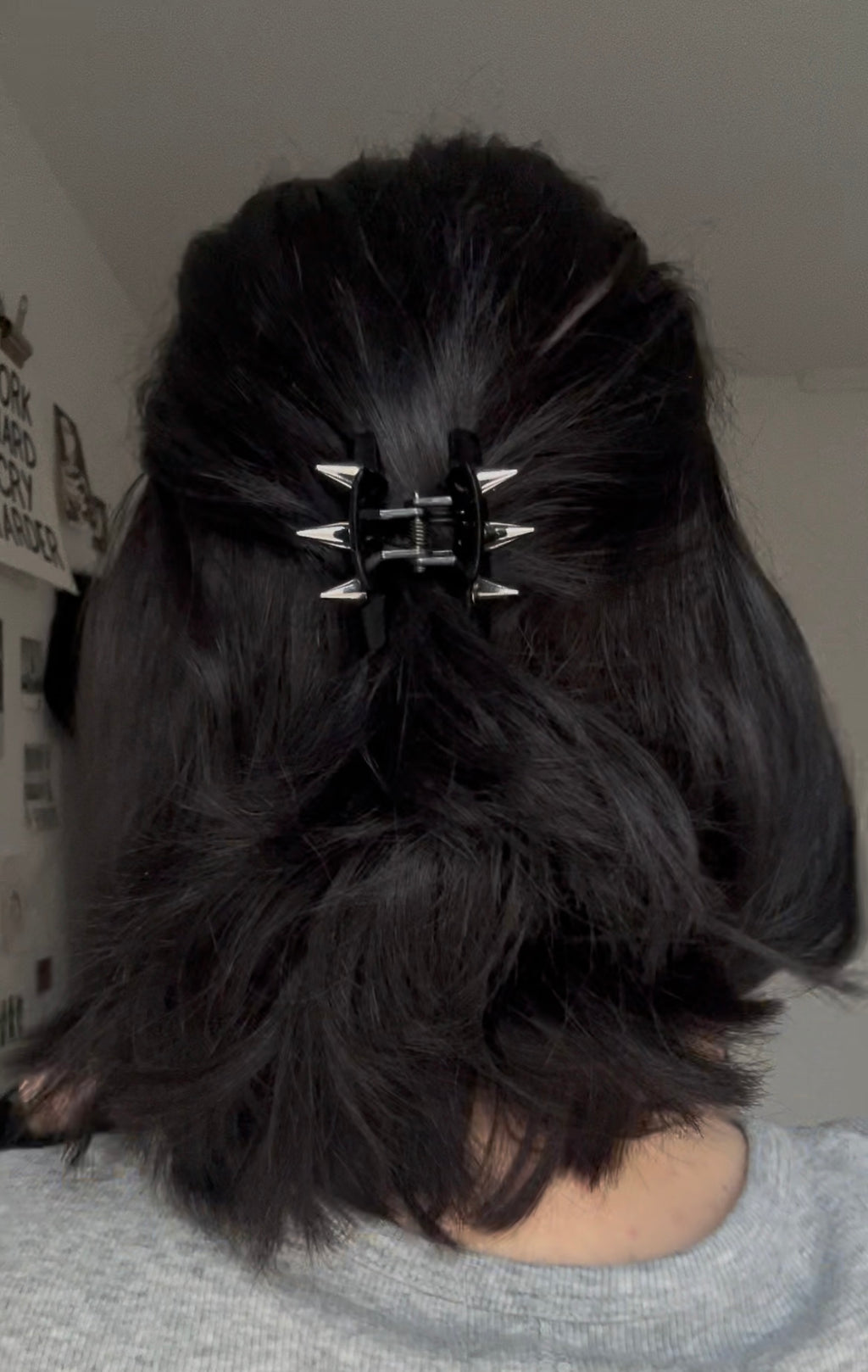 Close-up of a person with dark hair styled in an updo with a decorative hair clip.
