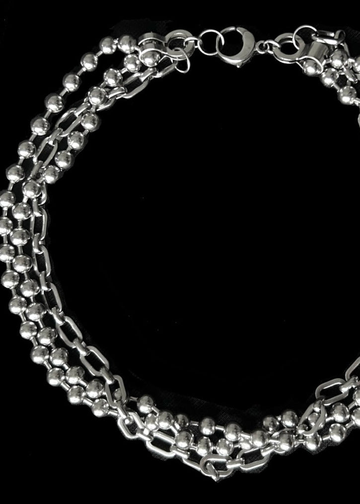 Silver chain necklace on a black background